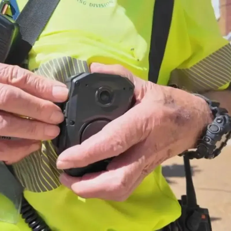 Medarbejder i gul refleksvest med en bodycam monteret på brystet